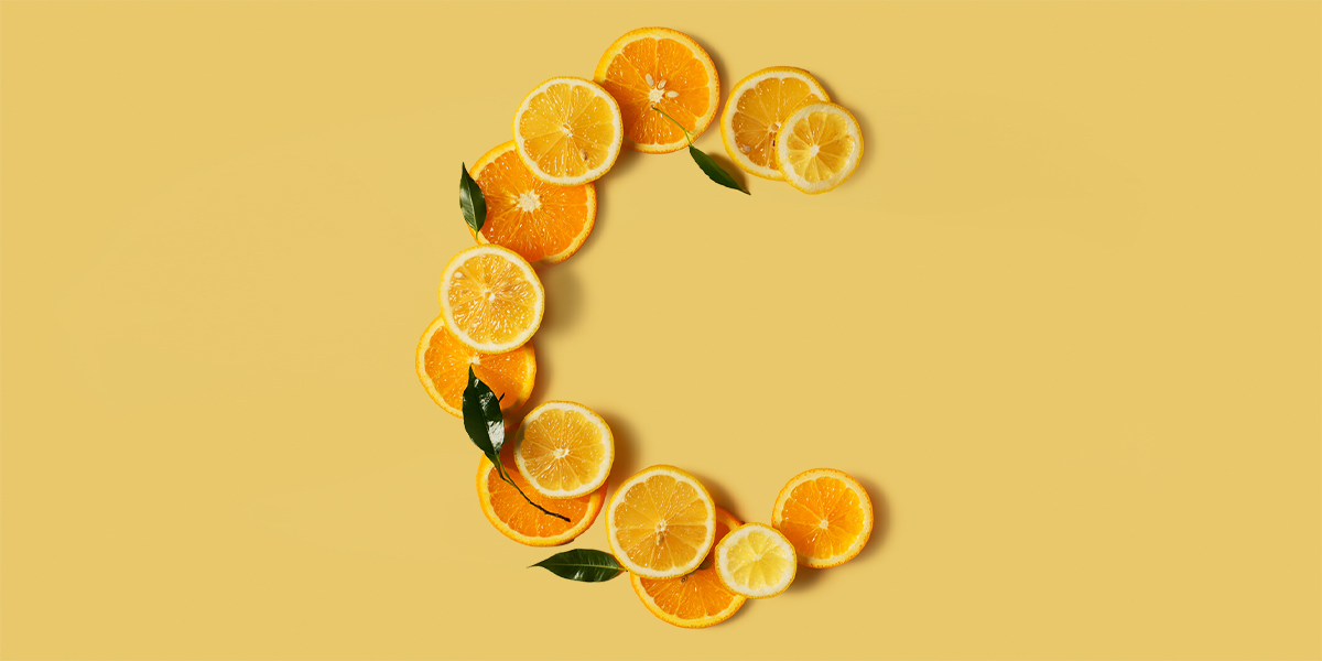 Tante fette di agrumi che messe insieme formano la lettera C su uno sfondo arancione
